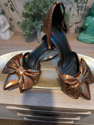 Zapatos dorados de tacón con lazo