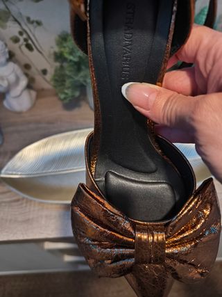 Zapatos dorados de tacón con lazo