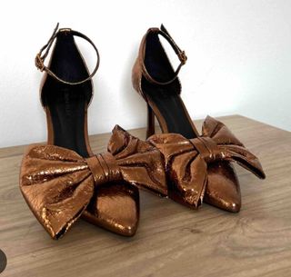 Zapatos dorados de tacón con lazo
