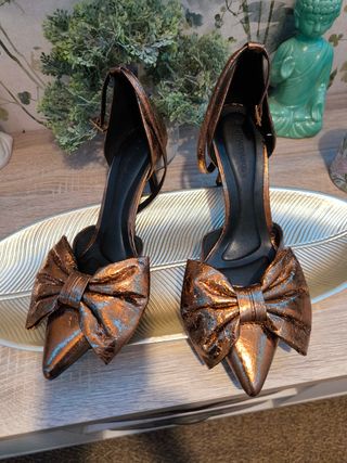 Zapatos dorados de tacón con lazo