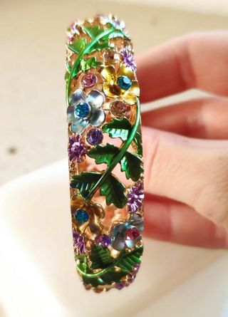 Pulsera dorada con flores y piedras