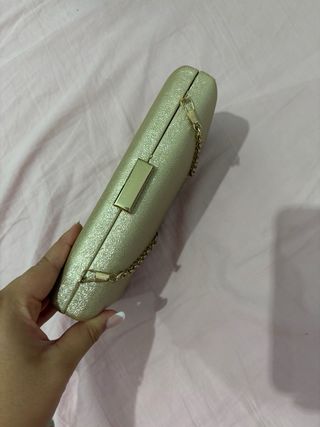 Bolso de mano dorado con cadena