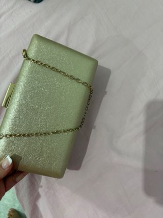 Bolso de mano dorado con cadena