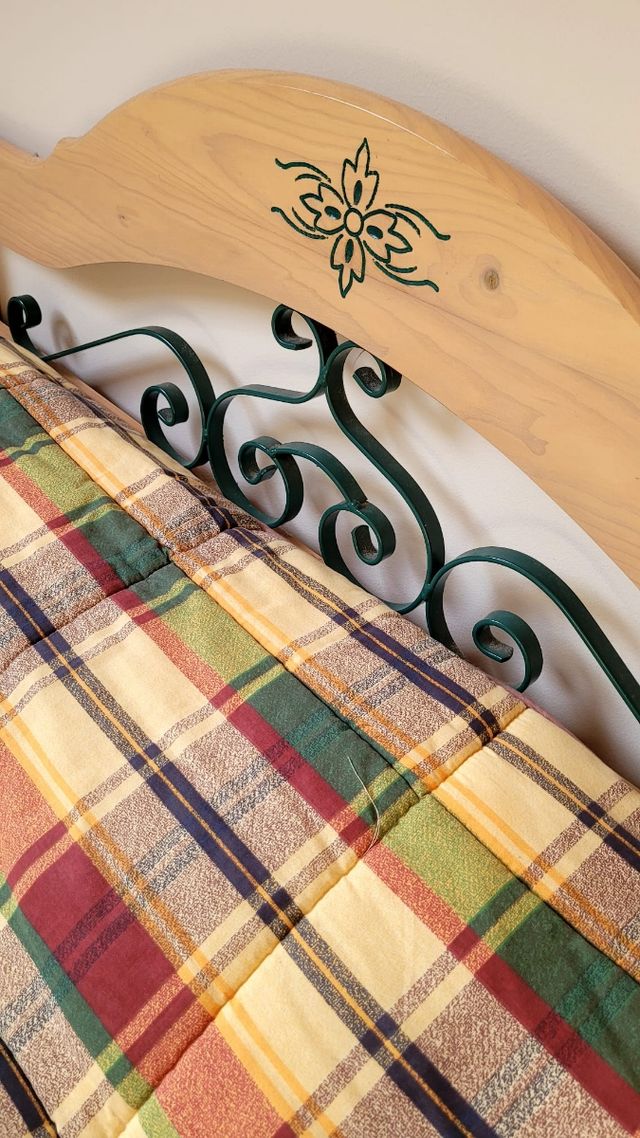 Cabecero de madera con forja y colcha a cuadros