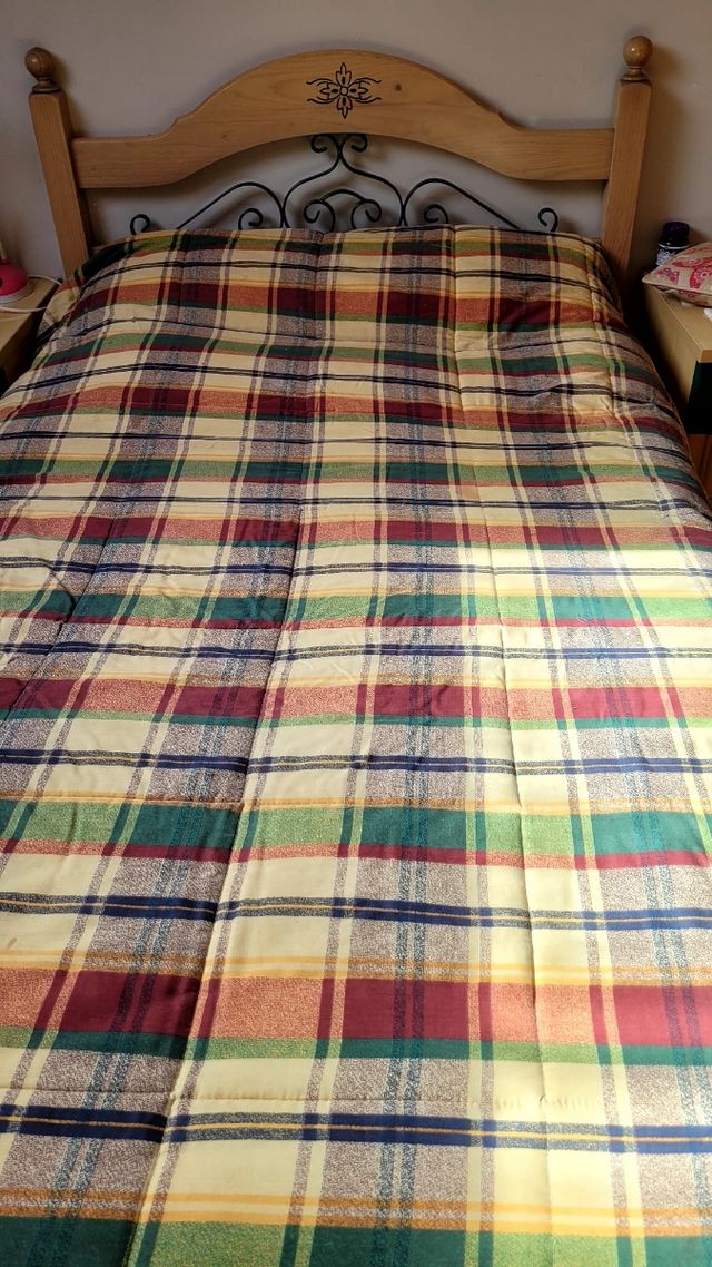 Cabecero de madera con forja y colcha a cuadros