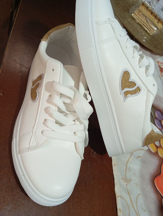 Nuove scarpe bianche con dettagli oro