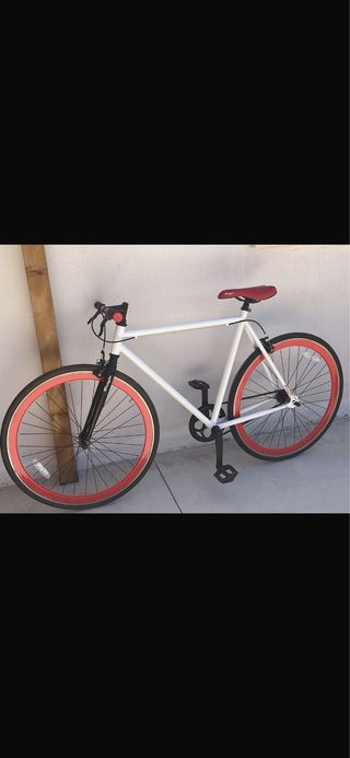Bicicleta blanca con ruedas rojas