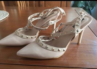 Zapatos de tacón beige con tachuelas doradas