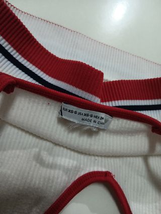Top deportivo blanco con ribetes rojos