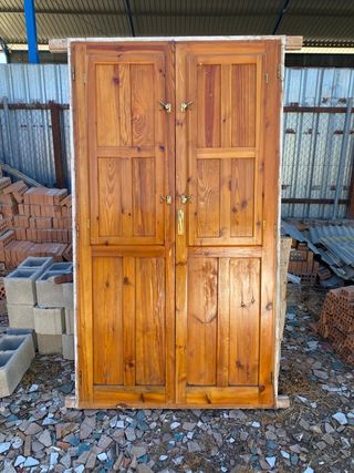 Puerta doble de madera con postigos
