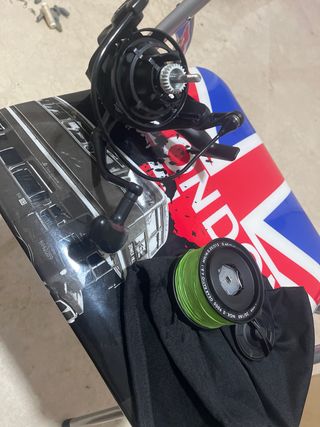 Carrete de pesca negro con sedal verde