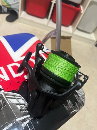 Carrete de pesca negro con sedal verde