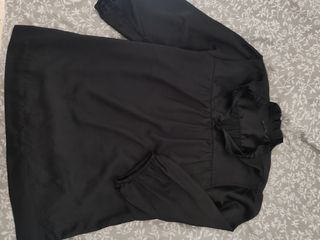 Blusa negra con cuello alto y volantes