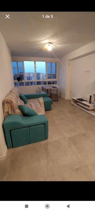 Sofá chaiselongue turquesa con taburetes y arcón