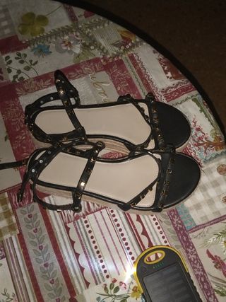 Sandalias planas negras con tachuelas doradas
