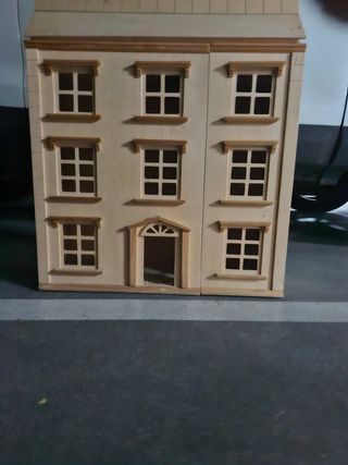Casa de muñecas de madera con accesorios.