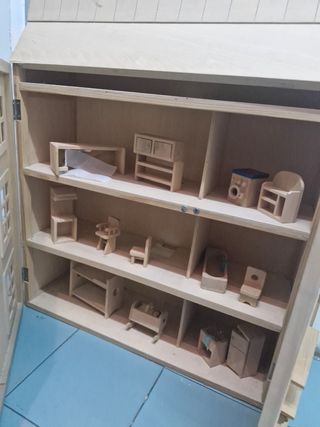 Casa de muñecas de madera con accesorios.
