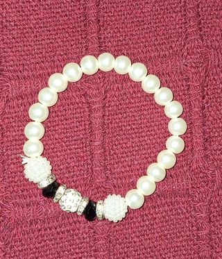 Pulsera de perlas blancas y detalles negros