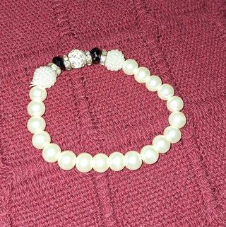 Pulsera de perlas blancas y detalles negros