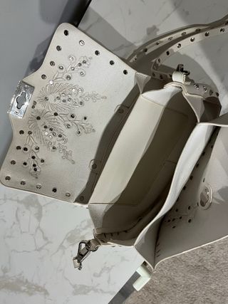 Bolso blanco de piel con tachuelas plateadas