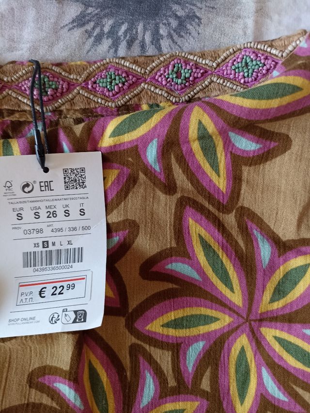 Minifalda tipo pareo con abalorios en la cintura