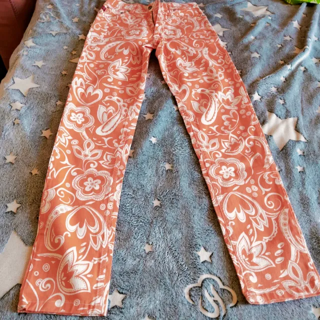 Pantaloni arancioni con fantasia bianca