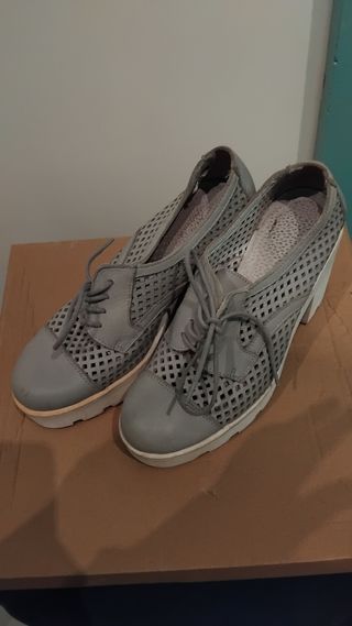 Zapatos grises con tacón y suela blanca