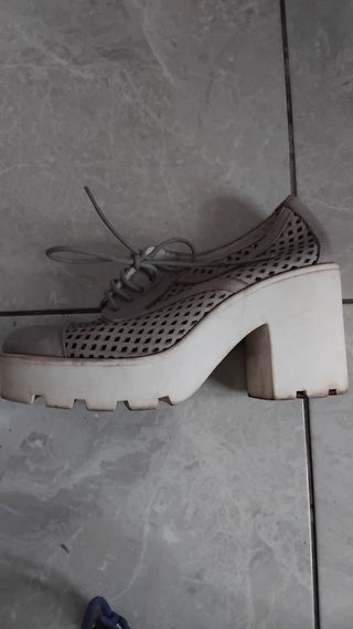 Zapatos grises con tacón y suela blanca