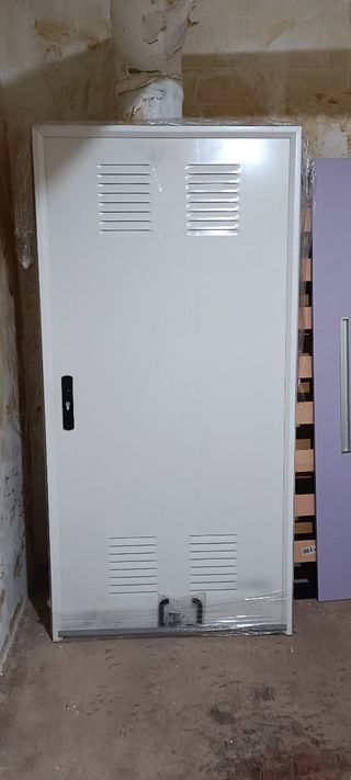 Puerta exterior blanca con rejillas