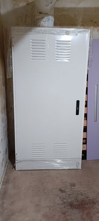 Puerta exterior blanca con rejillas