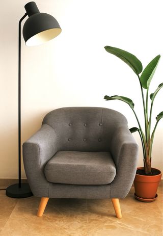 Sillón de tela gris con patas de madera