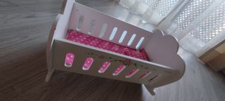Cuna de juguete blanca con cojín rosa