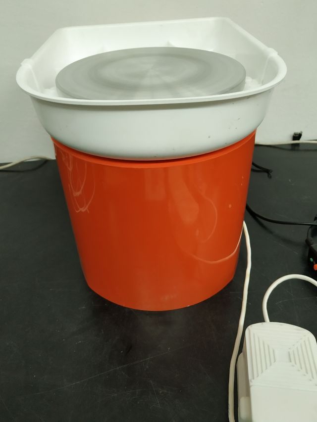 Máquina de cerámica naranja con pedal