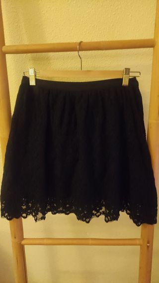 Falda de encaje corta negra.