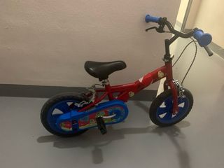 Bici infantil roja con pedales y ruedines