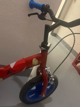 Bici infantil roja con pedales y ruedines