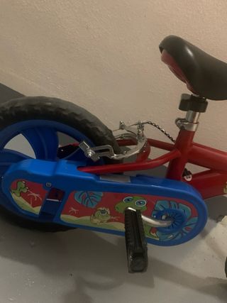 Bici infantil roja con pedales y ruedines