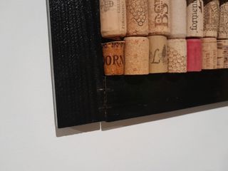 Panel decorativo de madera con corchos para fotos.