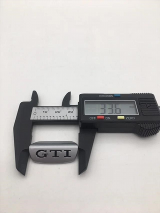EMBLEMA VOLANTE GTI LETRAS ROJAS O NEGRAS