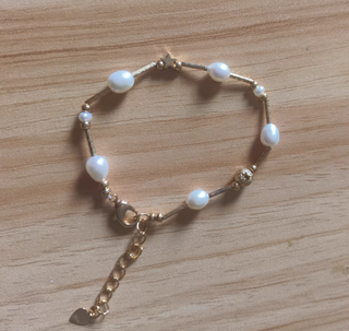 Pulsera de perlas y detalles dorados