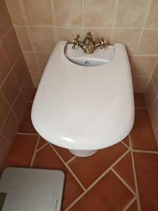 Bidé blanco con grifería dorada