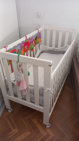Cuna de madera blanca con peluches