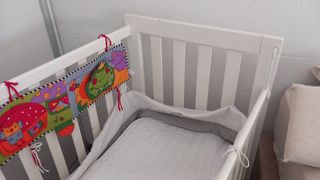 Cuna de madera blanca con peluches