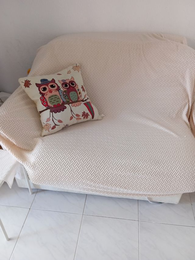 Sofá beige con cojín de búhos