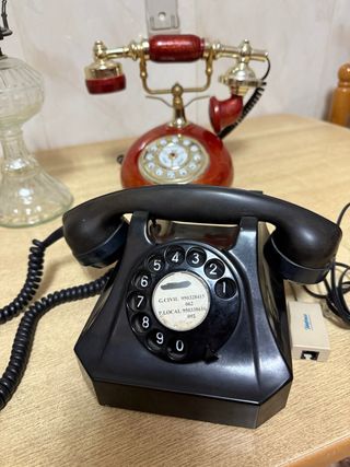 Teléfono antiguo negro y  lámpara sin tulipa 