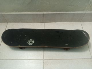 Monopatín negro con logo blanco