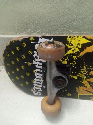 Monopatín negro con logo blanco