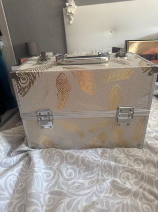Maletín de maquillaje dorado con plumas