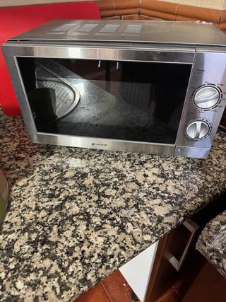 Microondas plateado con puerta abierta