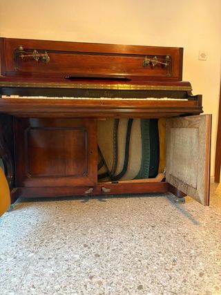 Piano antiguo de madera con candelabro